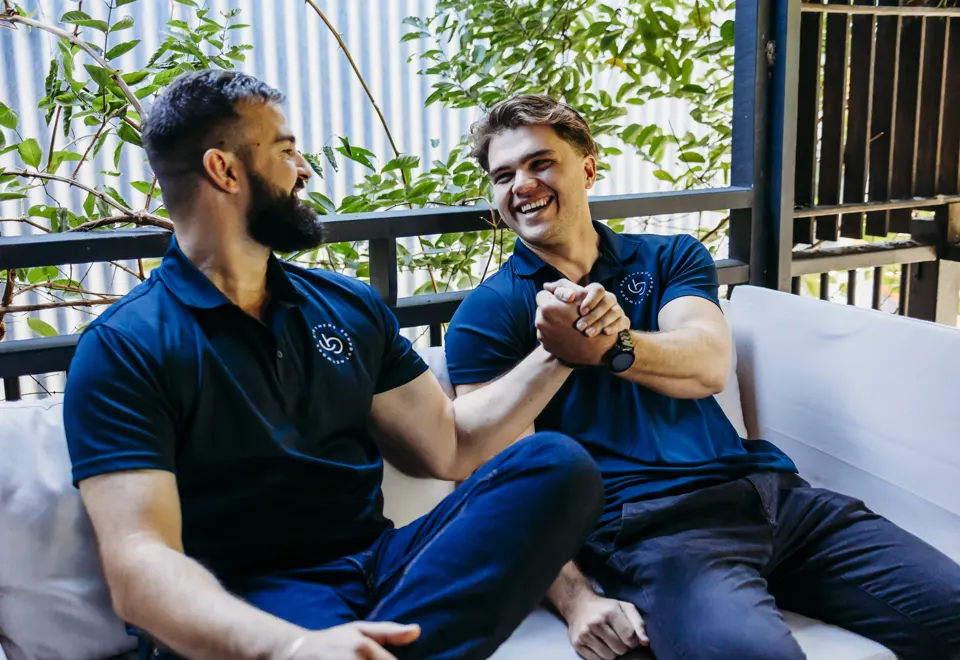 Two Brothers sharing a handshake and a laugh